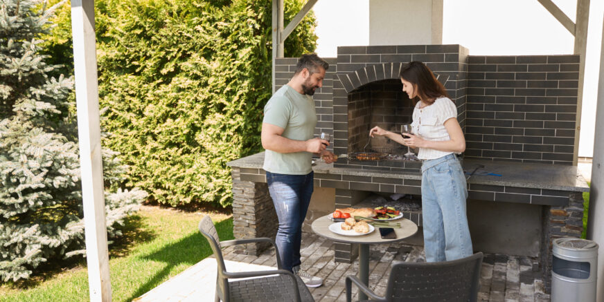 Spouses cook food together in the backyard Spouses cook food together in the backyard, people in comfortable casual clothes