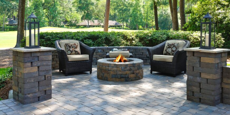 Beautiful outdoors pavers with two comfortable armchairs and a fire pit in a green environment A beautiful outdoors pavers with two comfortable armchairs and a fire pit in a natural green environment